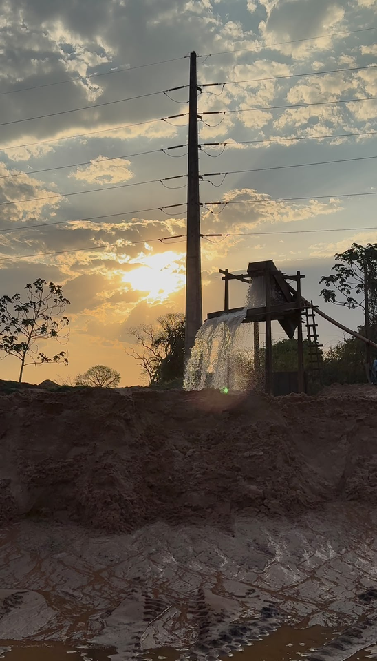 Carregadeira movimentando areia no pátio